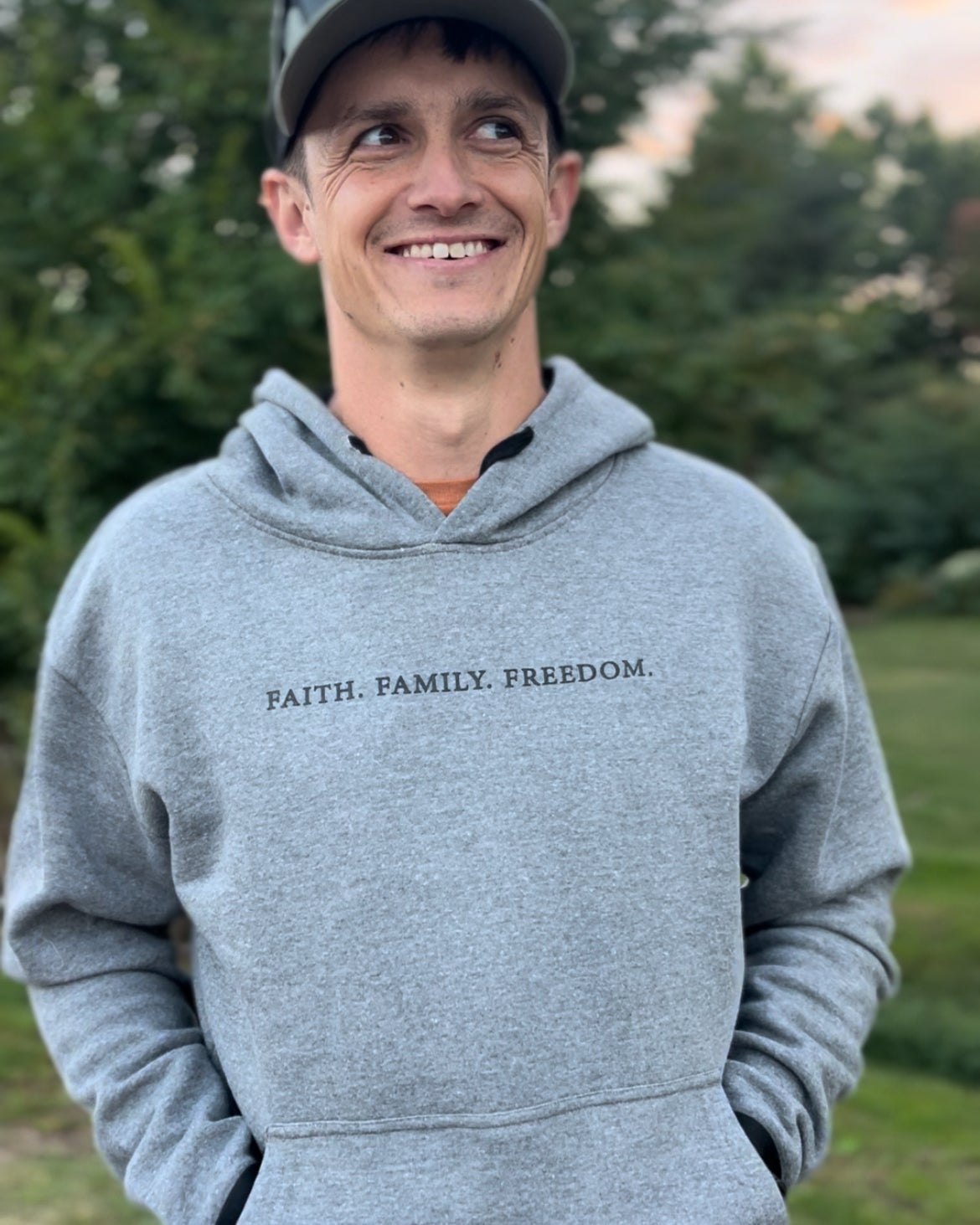 Man wearing a faith based hoodie with "faith, family, freedom" printed across the front.