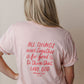 Person wearing a pink t-shirt with a Christian Bible Verse quote on the back against a plain background