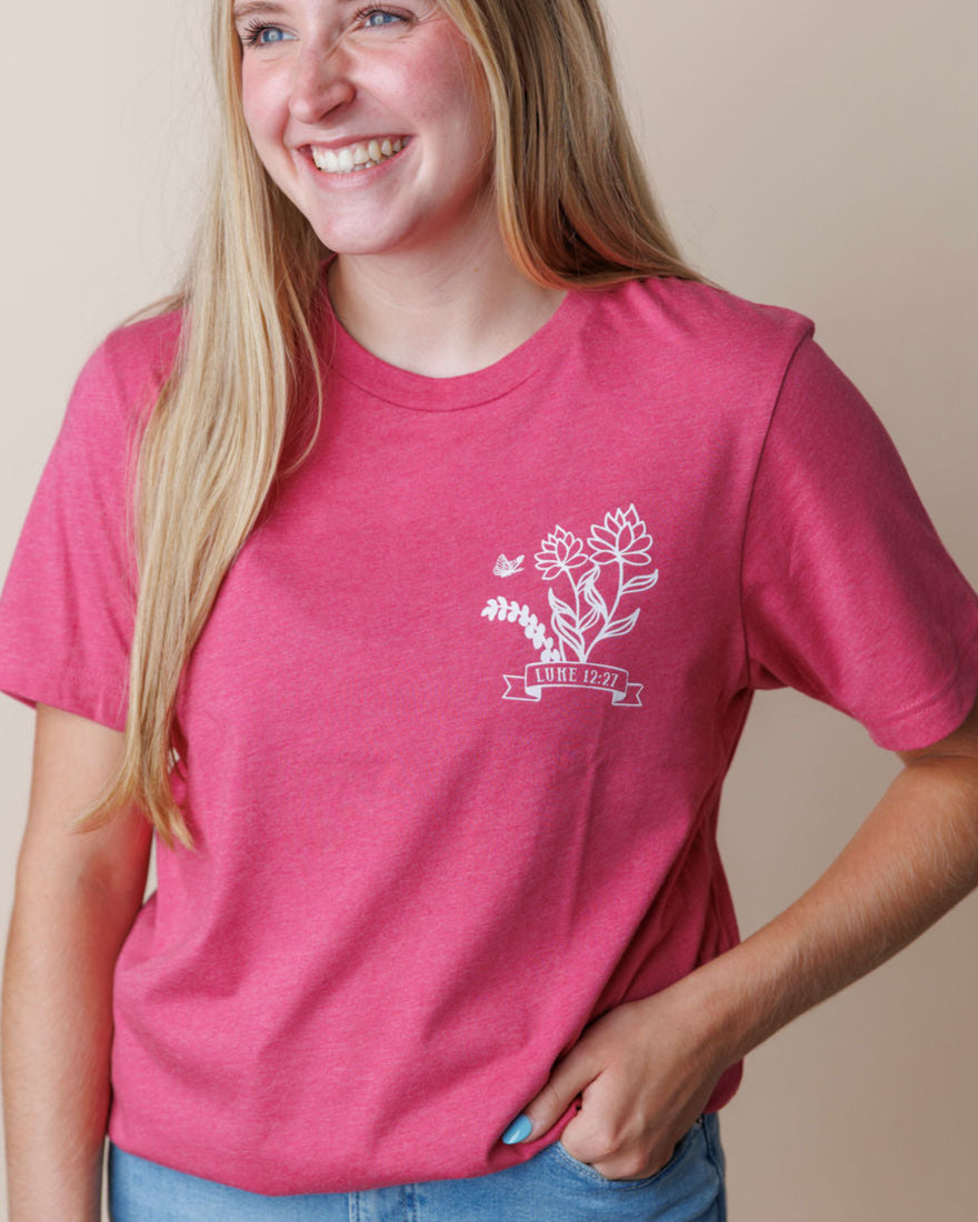 Girl wearing a raspberry faith based Christian tshirt with a Bible verse Luke 12:27