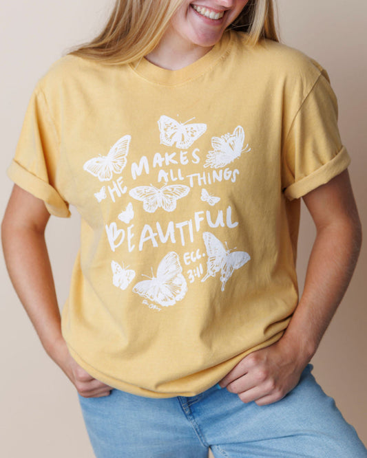 Girl wearing a yellow t-shirt with Christian butterfly design and Bible verse on a beige background