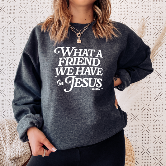 Charcoal gray Christian sweatshirt on a female model with white text that says "What A Friend We Have In Jesus" by Rohi Clothing